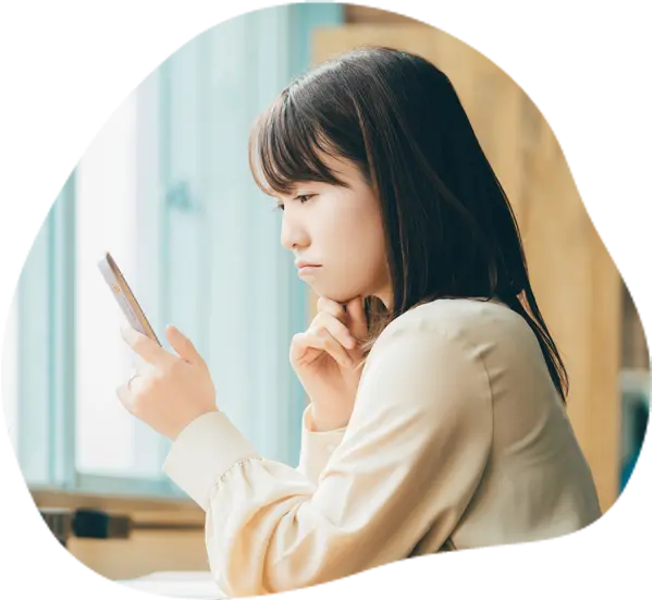 スマホで思い出の写真を見ながらプロに依頼すればよかったと後悔する女性